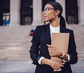 Woman holding papers outside of a government building